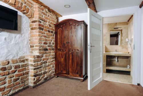 a bathroom with a brick wall and a wooden door at Hotel Legenda in Toruń