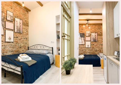 a bedroom with a bed and a brick wall at Simply Modern Apartment in Toruń