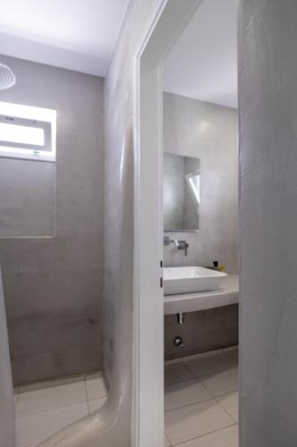 a white bathroom with a sink and a tub at Lorenzo Studios and Suites Paros in Naousa