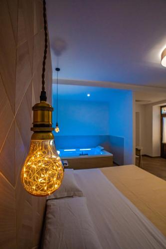 a bedroom with a light hanging over a bed at Le Querce Farmhouse in Agropoli
