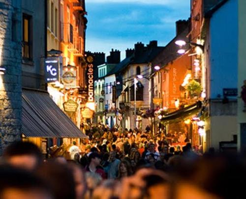 a crowd of people walking down a street at night at Griffin Lodge Guesthouse in Galway