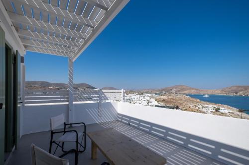 a balcony with a table and chairs and a view of the ocean at Lorenzo Studios and Suites Paros in Naousa