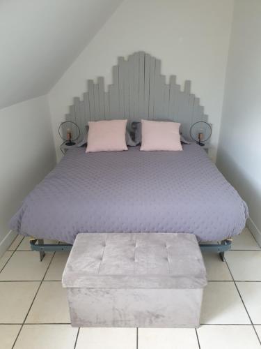 uma cama com duas almofadas cor-de-rosa em Duplex de Léane em Honfleur