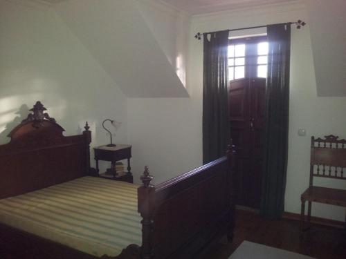 a bedroom with a canopy bed and a window at Casa Cardoso in São Martinho de Mouros