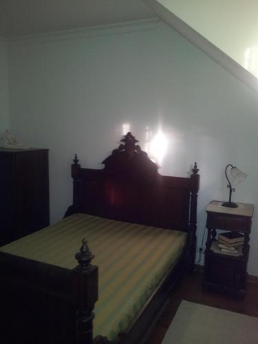 a bedroom with a bed with a light on the wall at Casa Cardoso in São Martinho de Mouros
