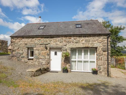 a stone cottage with a white door at Hendre Cottage in Trawsfynydd
