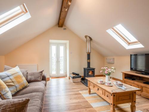 a living room with a couch and a tv and a table at Hendre Cottage in Trawsfynydd