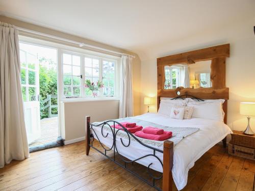 a bedroom with a bed with red towels on it at Kettle Cottage in Chipping Campden