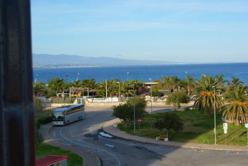 a bus is driving down a road near the ocean at Hotel Nettuno in Soverato Marina