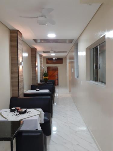 uma sala de jantar com sofás e mesas e um corredor em Hotel Rio Claro em Rio Claro