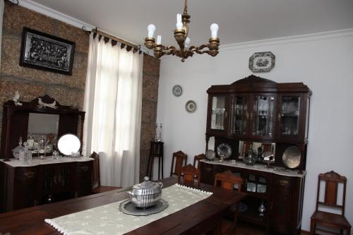a dining room with a table and a chandelier at Casa Cardoso in São Martinho de Mouros
