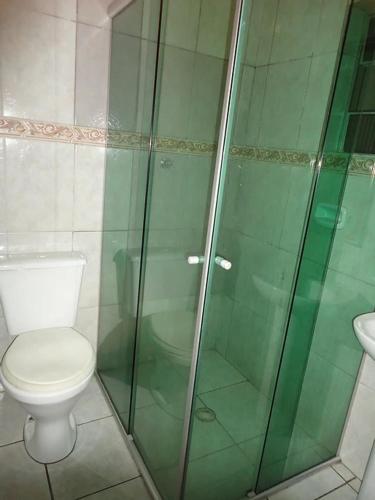 a bathroom with a toilet and a glass shower at Hotel Styllus in São Paulo