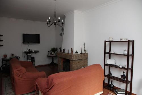 a living room with two couches and a fireplace at Casa Cardoso in São Martinho de Mouros
