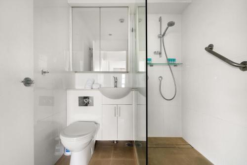 a white bathroom with a toilet and a shower at Harbourside #76 in Sydney