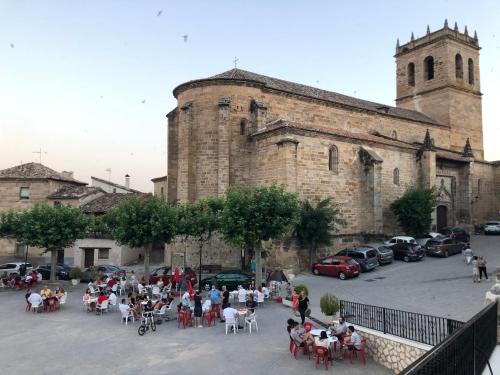a group of people sitting at tables in front of a building at El Refugio de Su - Casa Rural in Auñón