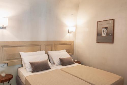 a hotel room with a bed with two pillows at Villa LuxL in Fira