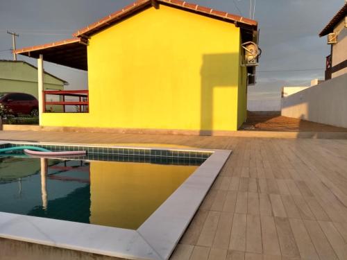 a yellow house with a pool in front of it at Chalés Serra Monte in Monte das Gameleiras