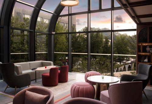 a room with large windows and tables and chairs at Mondrian Seoul Itaewon in Seoul