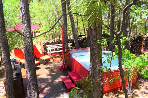 einen Hinterhof mit einem Whirlpool, Stühlen und Bäumen in der Unterkunft Dream Getaway-Secluded Hot Spa-Walk to Village-Walk to Pineknot Trailhead-Plus King Bed! in Big Bear Lake