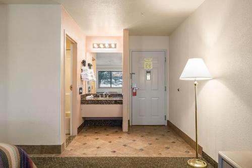a hallway with a bathroom with a sink and a lamp at Grand Canyon Inn and Motel - South Rim Entrance in Valle