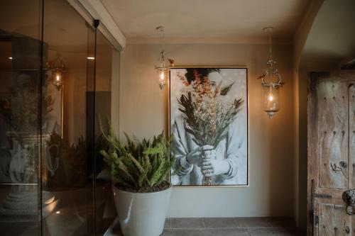 um quarto com uma pintura e um vaso de flores em El Golpe de Vista em San Miguel de Allende