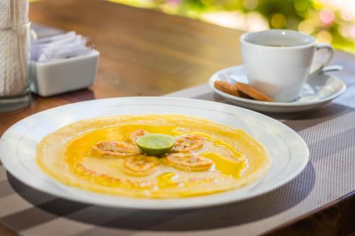 un piatto di cibo su un tavolo con una tazza di caffè di Amed Beach Resort ad Amed