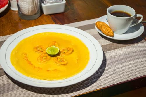 un piatto di zuppa di gamberi con una tazza di caffè di Amed Beach Resort ad Amed