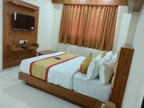 a bedroom with a large bed and a television at hotel restandride in Anand