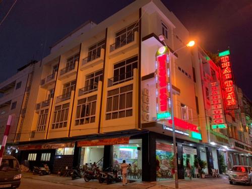 a building with neon signs on a street at night at Mekong Rose Hotel in Can Tho