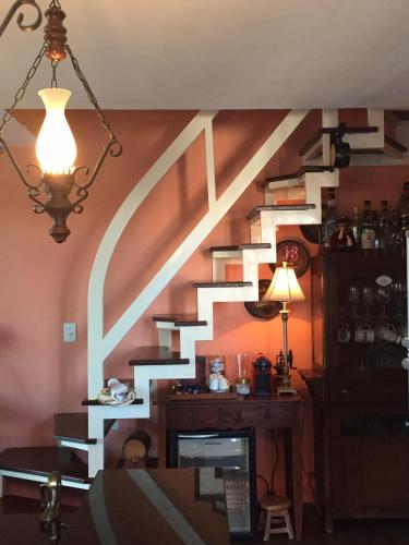 a room with a spiral staircase with a desk and a lamp at Chalé Charmoso em Bananeiras no condomínio exclusivo Serra Nevada in Bananeiras