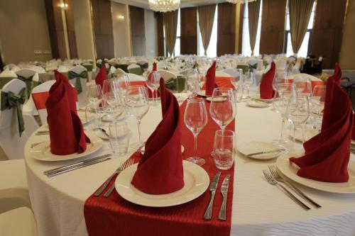 a table with red napkins and wine glasses on it at Wyndham Grand KN Paradise Cam Ranh in Cam Ranh