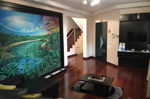 a living room with a large painting on the wall at Ammy’s House in Câmara de Lobos