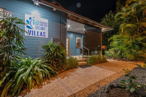 um edifício azul com um cartaz que lê villas de cozinha sustentáveis em Blue Summit Hideaway em Yungaburra