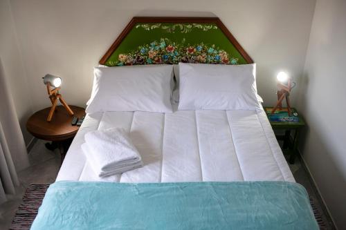 een bed in een slaapkamer met 2 lampen op tafels bij Pousada Rua de Lazer in Domingos Martins