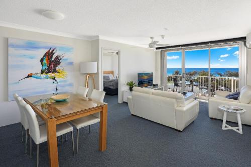 a living room with a dining room table and a couch at Elouera Tower in Maroochydore