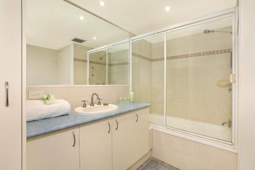 a bathroom with a sink and a shower at Elouera Tower in Maroochydore