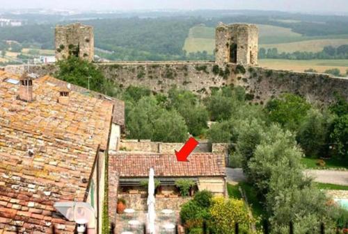 an old building with two towers on top of roofs at Monteriggioni Castello in Monteriggioni