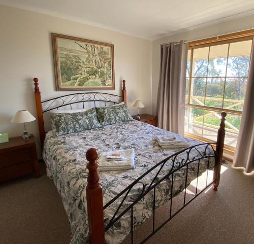 a bedroom with a bed and a large window at Windmill Cottage in Clare