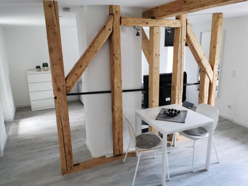 een witte tafel en stoelen in een kamer met houten balken bij Traumhaftes Apartment zentral in Bad Berleburg in Bad Berleburg