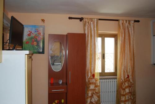 sala de estar con armario y TV en Rustico Rosmarino, en Castiglion Fiorentino