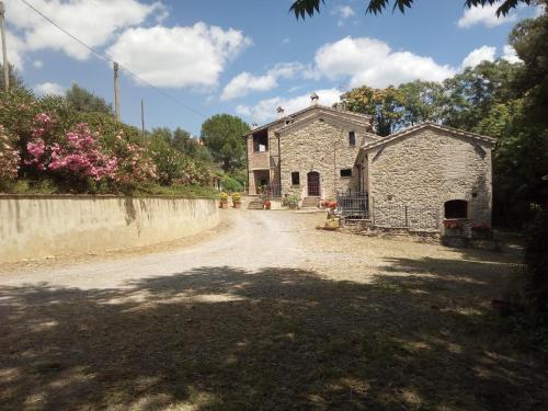 un viejo edificio de piedra en un camino de tierra en Casa in campagna per vacanze in Umbria con piscina, en Vicolo Rancolfo