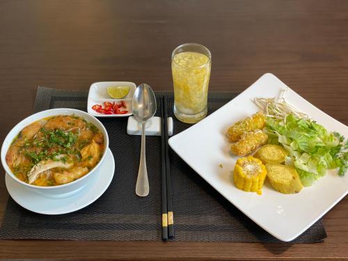 a table with a plate of food and a bowl of soup at Golden Season Hotel in Ninh Binh