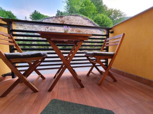 a wooden table and two chairs on a deck at Filip&Yana Apartment in Mavrovo