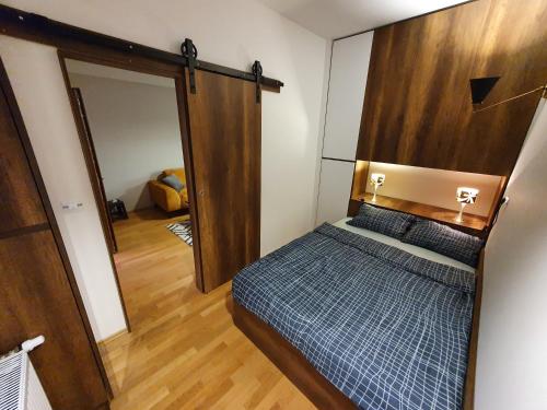 Filip&Yana Apartment في مافروفو: غرفة نوم مع سرير مع اللوح الأمامي الخشبي ومرآة