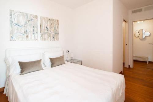a bedroom with a white bed with two pillows at PORTOPICCOLO Luxury Penthouse Beach Included in Sistiana