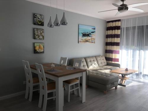 a living room with a dining room table and a couch at GARDENIA Apartament Przy Plaży 17 in Dziwnów