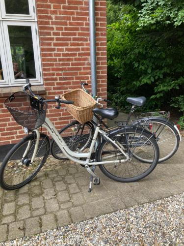 two bikes parked in front of a brick building at Varde Bed and Kitchen in Varde