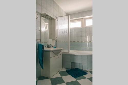 bagno con vasca e lavandino di Aloé Apartman Sopron a Sopron