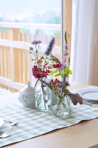 a table with two vases of flowers on a table at Bauernhof Gschmeidler in Sankt Johann im Saggautal