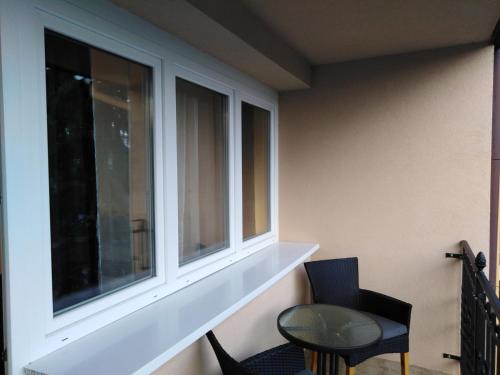 a room with two windows and a table and chairs at Filsdeger Ház - Central Rooms & Apartmans in Eger